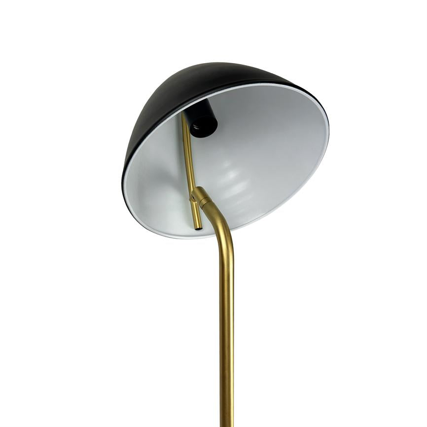 Gulvlampe, skråt vinklet skærm med sort yderside og hvid inderside, gylden buet stang, placeret mod ensartet hvid baggrund.